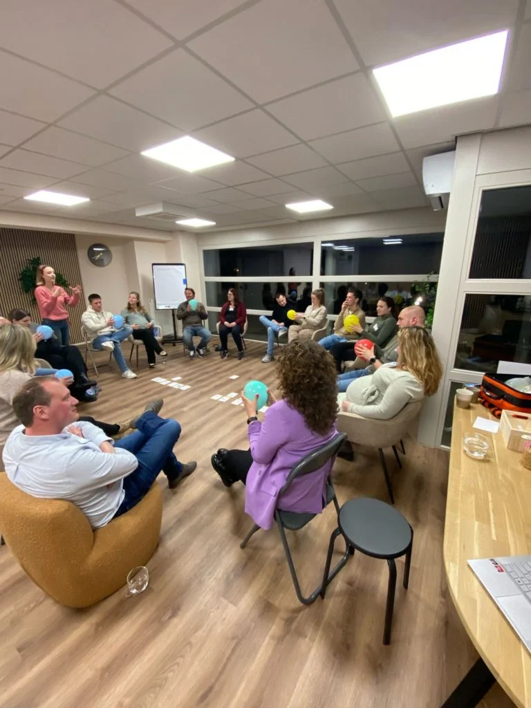 Zwangeren en partners oefenen met ballonnen tijdens een groepsbijeenkomst